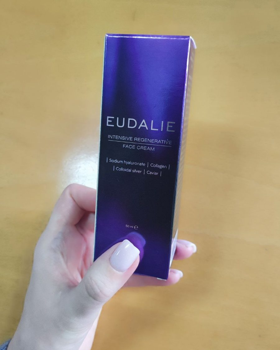 Μωβ κουτί της Eudalie Intensive Regenerative Face Cream κρατημένο στο χέρι