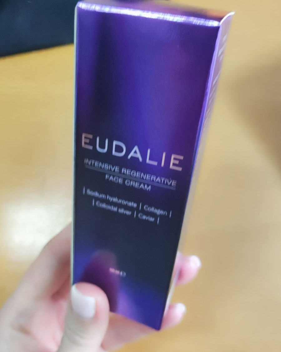 Violetter Karton von Eudalie Intensive Regenerative Face Cream in der Hand gehalten
