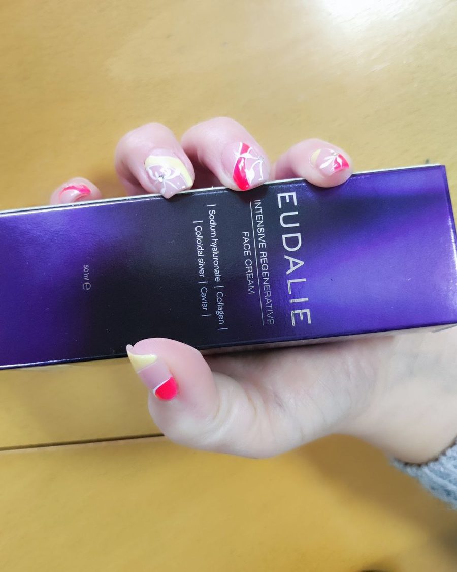 Fioletowe pudełko Eudalie Intensive Regenerative Face Cream trzymane w dłoni
