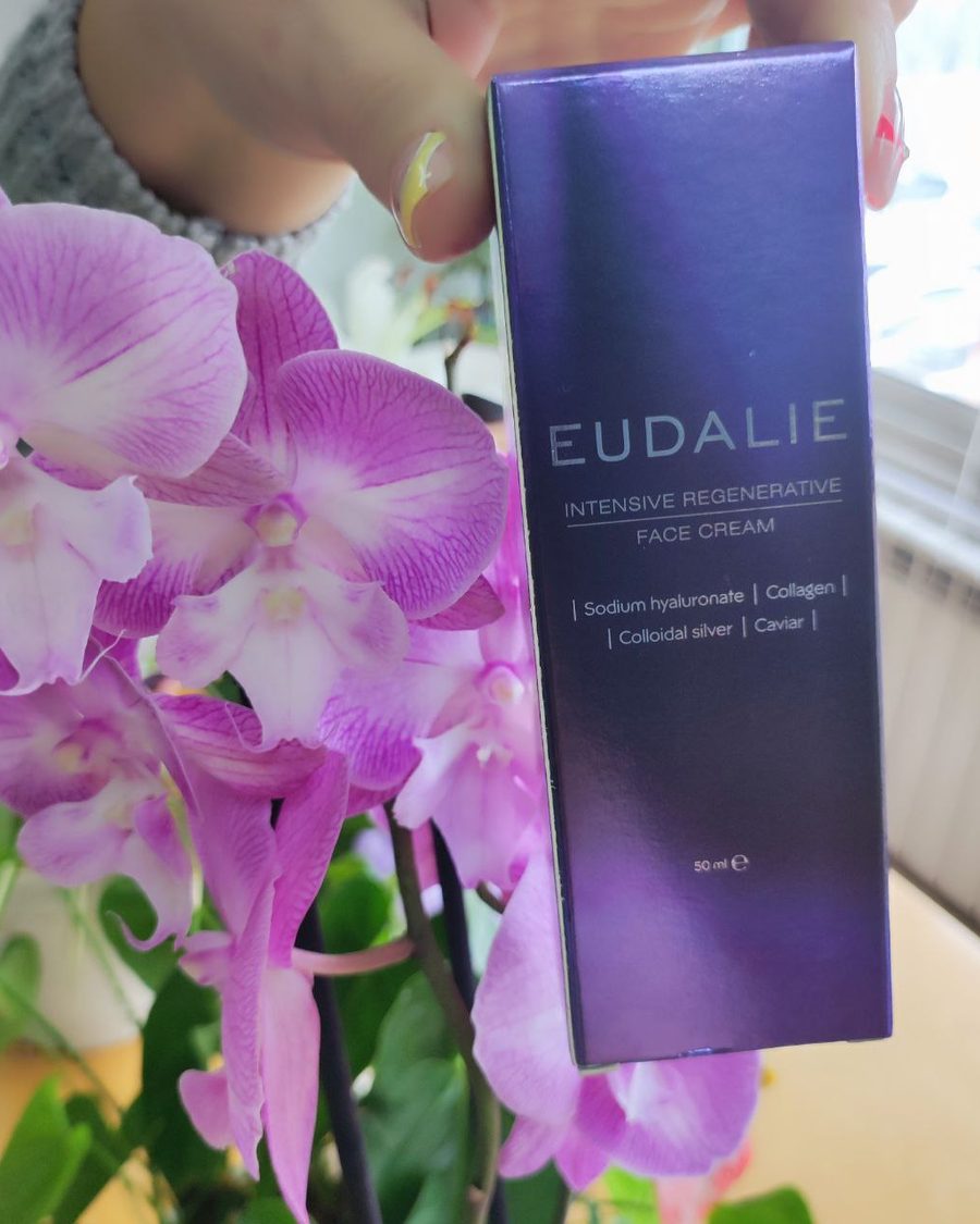 Caixa roxa de Eudalie Intensive Regenerative Face Cream segura na mão