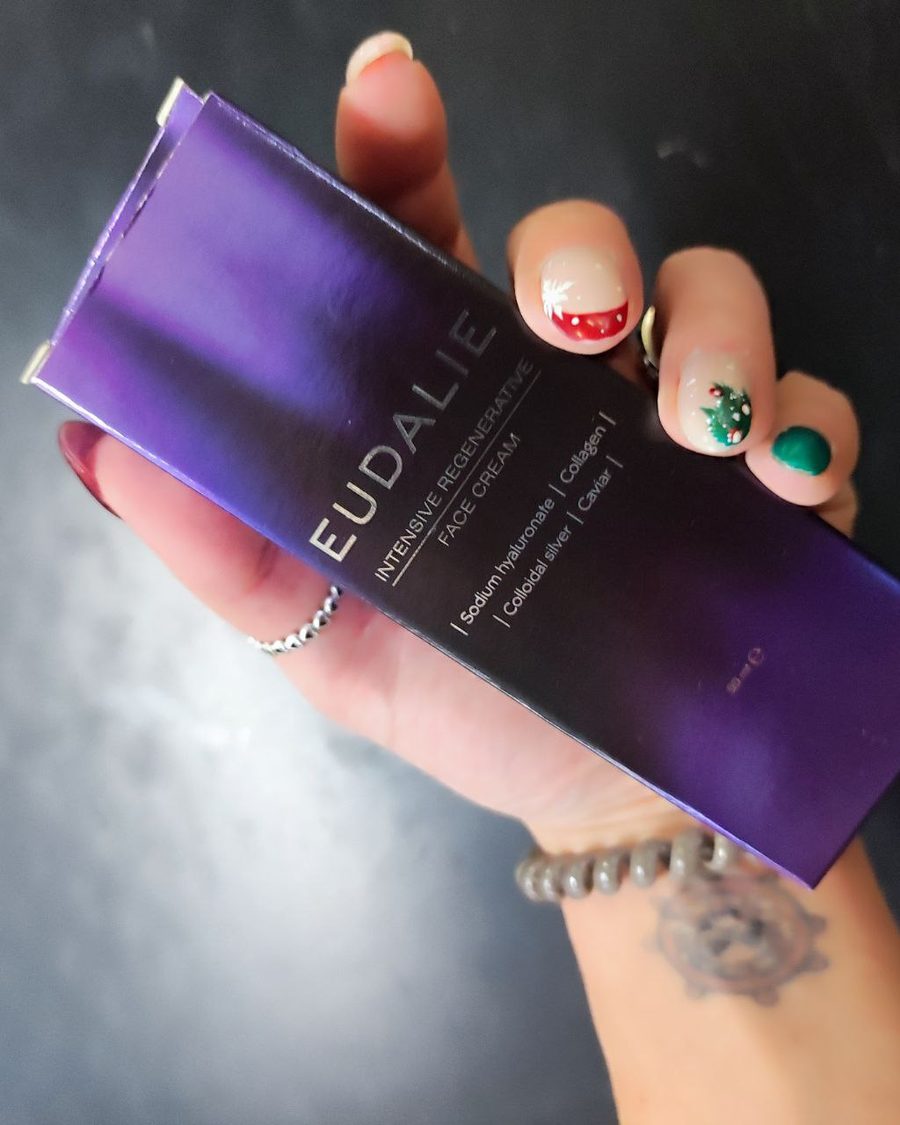 Vijolična škatlica Eudalie Intensive Regenerative Face Cream v roki